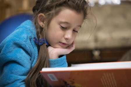 Child girl reading her favorite storyの写真素材