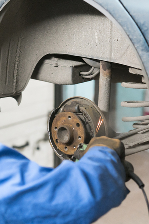 Close-up repair drum brake of car wheel in garage.の写真素材