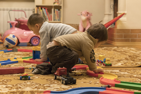 Two boys play toys in the houseの写真素材