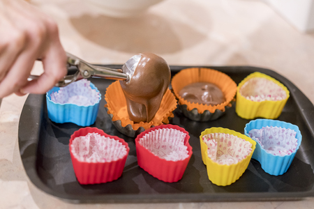 Pouring Cake Mix Into Baking Muffins Trayの写真素材
