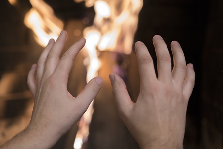 man's hands against the background of the fireの写真素材