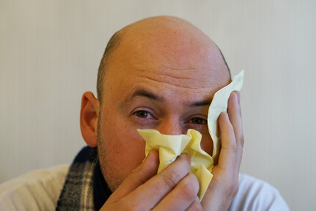 A cold man blows his noseの写真素材