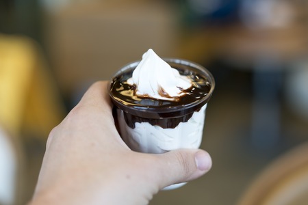 Hand with chocolate ice creamの写真素材