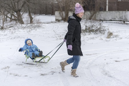 Happy family (mother with small boy and girl) in winter city park