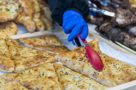 Street food pizza. The seller's hand