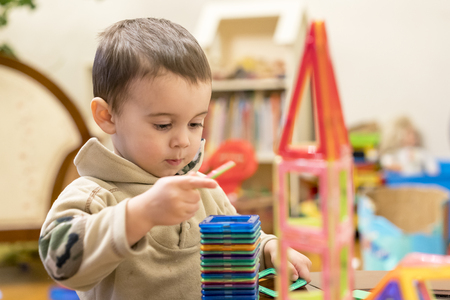 Cute child playing with magnetic constructor toy.の写真素材