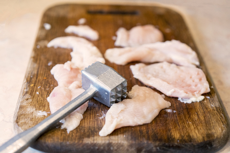 A hammer for meat. chicken fillet on a wooden dockの写真素材