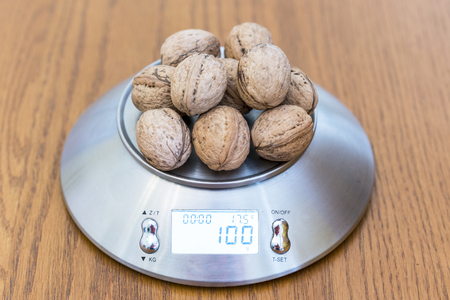 One hundred grams of walnuts on the scalesの写真素材