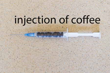Coffee dependence. Syringe and grains of coffee. The inscription "Coffee injection"の写真素材