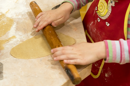 Little girl rolls out the doughの写真素材