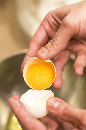 Female hands with an open chicken egg.の写真素材