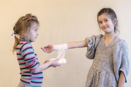 The girl bending her sister's hand.の写真素材