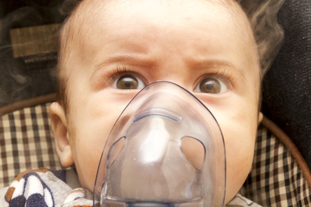 Baby using medical respiratory inhalator mask vapor seam treatment for flu