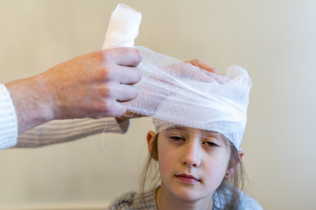 Doctor bandaged the girl's head.の写真素材