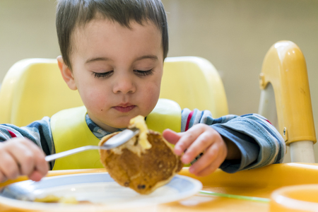 Baby boy 2 years old eating pancake.の写真素材