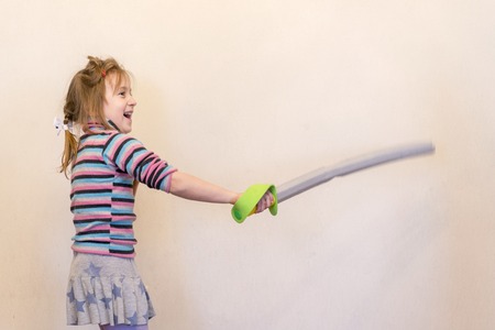 The girl is holding a toy saber. Playing the Knight.の写真素材