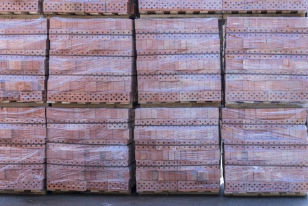 Clay brick's pallet at the storage yard. pallets with bricks in the building store. Racks with brick. Masonry, stoneworkの写真素材