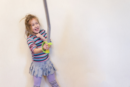 The girl is holding a toy saber. Playing the Knight.の写真素材