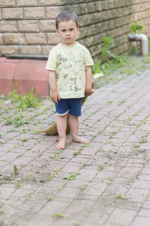 baby boy sweeping the yard. little boy my mother's helper, sweeping brush the floor.の写真素材
