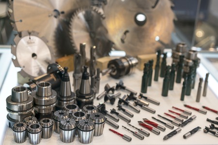 New saws and drills on the stand. New modern industrial drills and mills of the different sizes....
