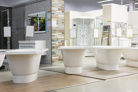 hite bath in the building store. baths in the plumbing store. Sanitary engineering shop. White bathrooms. shop baths. Plumbing. new baths. Bathroom on beautiful forged legs.の写真素材
