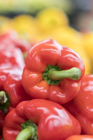 close up of red peppers on market stand. Ripe red bell peppers on the shelf in grocery storeの写真素材