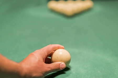 A man's hand puting a billiard ball. Preparation for the decisive blow.の写真素材