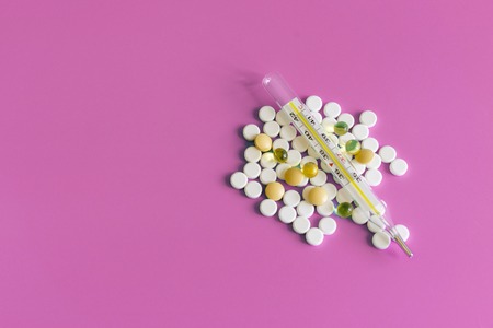 Pills Drugs and Thermometer, whiteTablets Capsule on blue, Health and Medicine Concept. White medical pills on a pink background. copy space.の写真素材