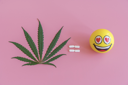 concept of good mood. marijuana = good mood. A sheet of marijuana and a smiley. Concept of fun and happinessの写真素材