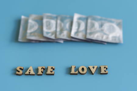 the concept of safe sex. inscription safe love. Condoms on a blue background.の写真素材