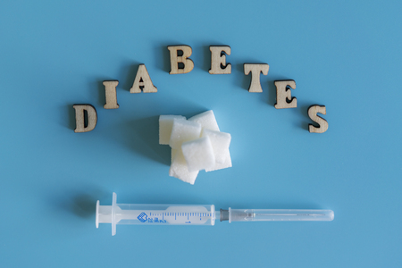 Diabetes, sugar and syringe on a blue background.の写真素材