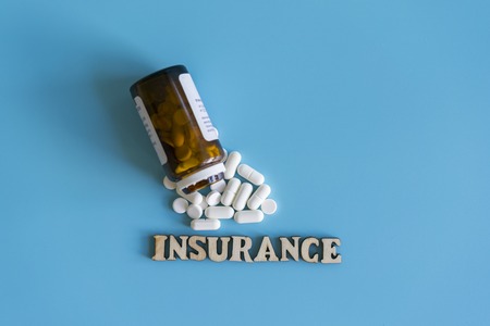 The concept of health insurance. Insurance inscription on the background of tablets.