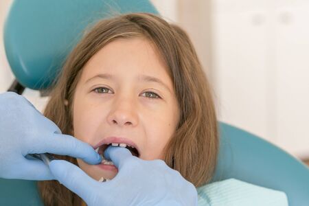 Little girl at the reception in the dentist's office. little girl sitting in a chair near a dentist...