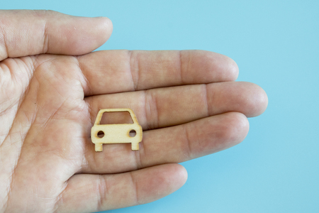 Car insurance. Man is holding car. my car. man hand holding car on a blue backgroundの写真素材