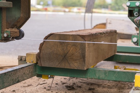 Sawmill. Process of machining logs in equipment sawmill machine saw saws the tree trunk on the plank boards. Wood sawdust work sawing timber wood wooden woodworkingの写真素材