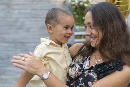 Mom holds a child in her arms. A happy family. Young mother holding her baby in her arms and stroked my mothers child litso.Portret mother and little sonの写真素材