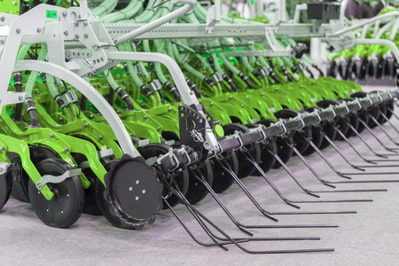 Corn harvester head with several silver blades. Agricultural machinery for soil cultivation