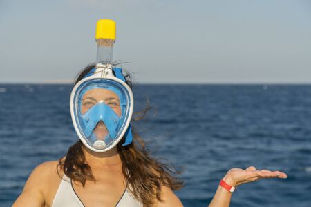 Funny young woman in a mask for swimming on the background of the sea. copy spase. close-up