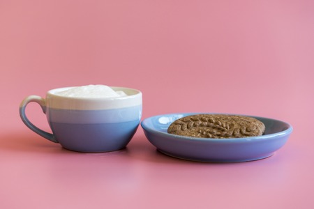 cup of cappuccino, cookies with chocolate. coffee cup with cookie for breakfast morning. On a pink...