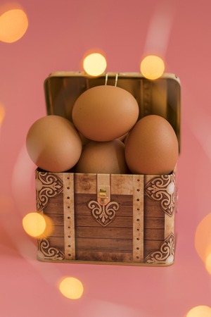 Easter eggs in a chest on a pink background. bokeh. vertical photo.の写真素材