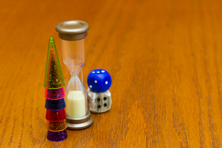 Six colored pawns and two dice isolated on a wooden background macro