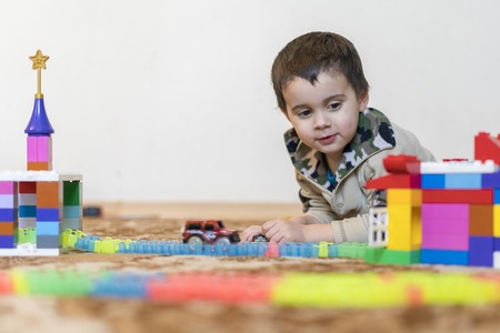 little smiling boy playing with constructor toy. Boy playing intellectual toysの写真素材