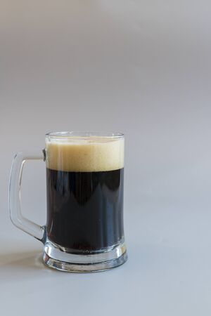 Glass of dark beer on a gray background. vertical photo.の写真素材