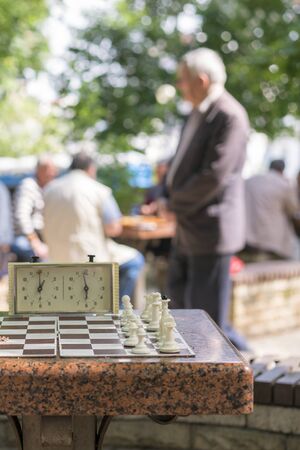 Chess board with pieces and clock on wooden desk In connection with the chess tournament. Chess...