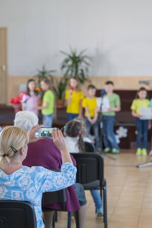 Performance by talented children. Children on stage perform in front of parents. image of blur kid 's show on stage at school , for background usage. vertical photo. Blurry.の写真素材