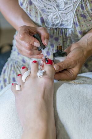 pedicure process macro closeup. pedicure process and spa procedure macro closeup. Master does pedicure for client. Pedicure process. Girl draws toenails. vertical photo.の写真素材