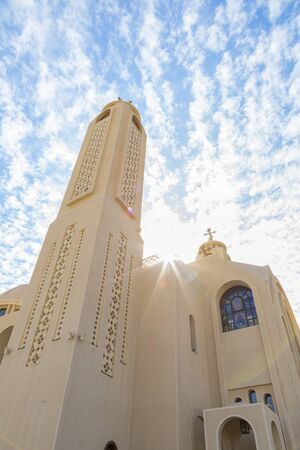 Coptic Orthodox Church in Sharm El Sheikh, Egypt.Against the backdrop of a beautiful sky with clouds. All Saints Church. Concept of the righteous faith. vertical photo.の写真素材