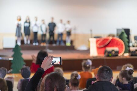 Children at school perform on stage in front of parents. Young talents on stage. blurry.の写真素材