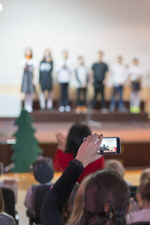 Children at school perform on stage in front of parents. Young talents on stage. vertical photo....