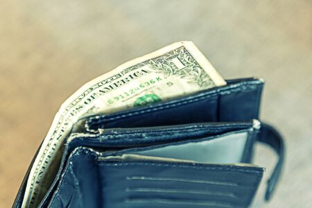 Empty male wallet with one dollar bill. financial wellness. copy space.
